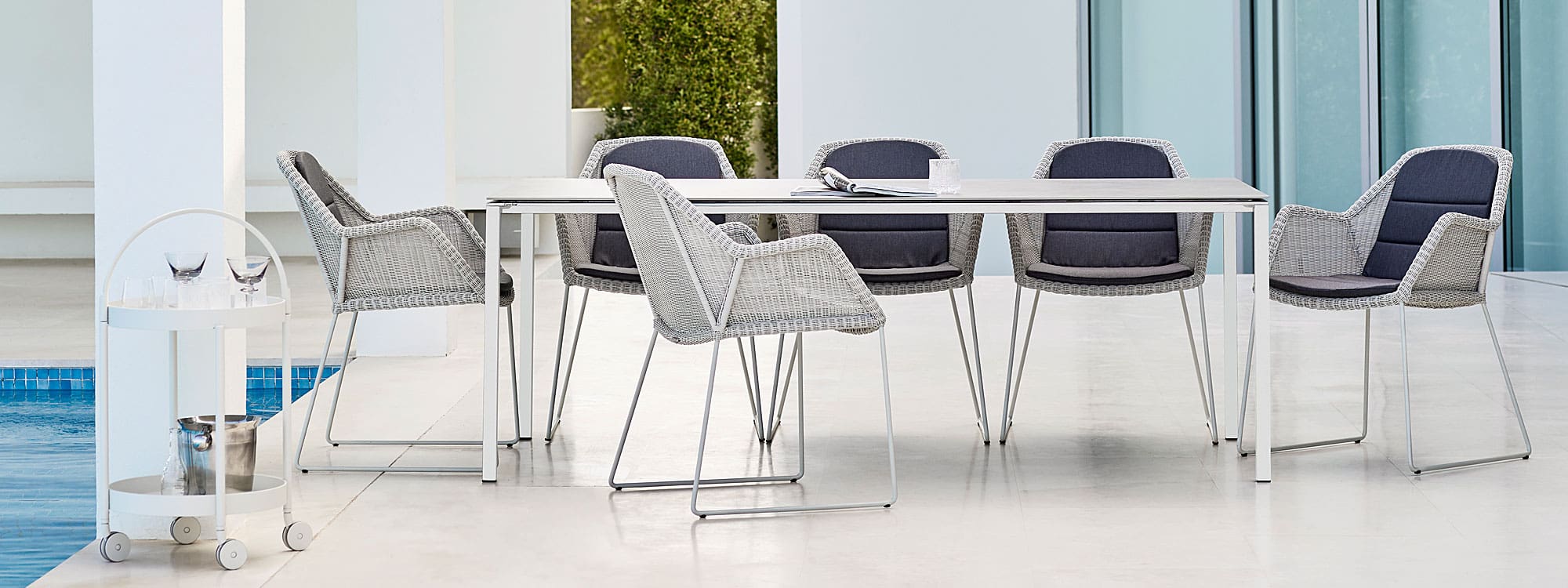 Image of white-grey Breeze woven dining chairs with sled leg and Pure garden dining table by Cane-line