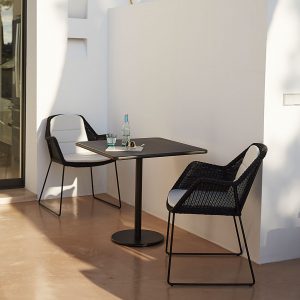 Image of pair of Breeze garden chairs in black Cane-line weave and small black Go table on shady terrace