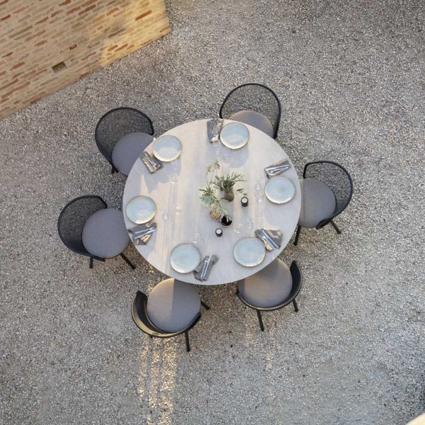 Image of aerial view of Branta round garden table and Baza chairs in courtyard in fading evening light, set ready for dinner