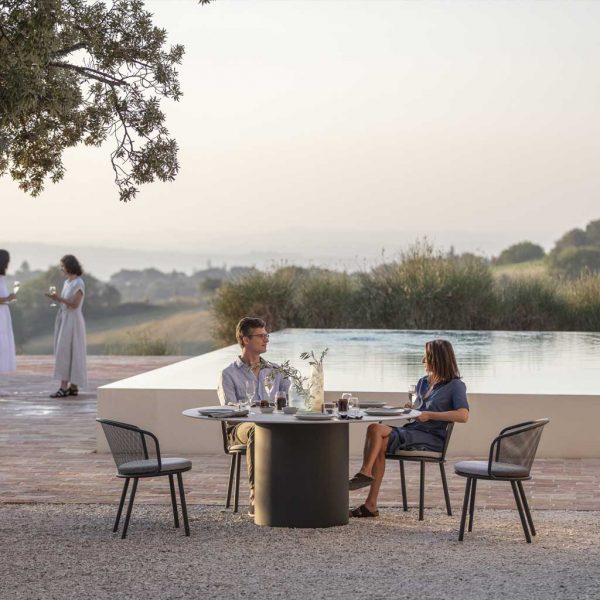 Image of Branta circular garden dining set on sultry terrace in front of swimming pool and olive trees