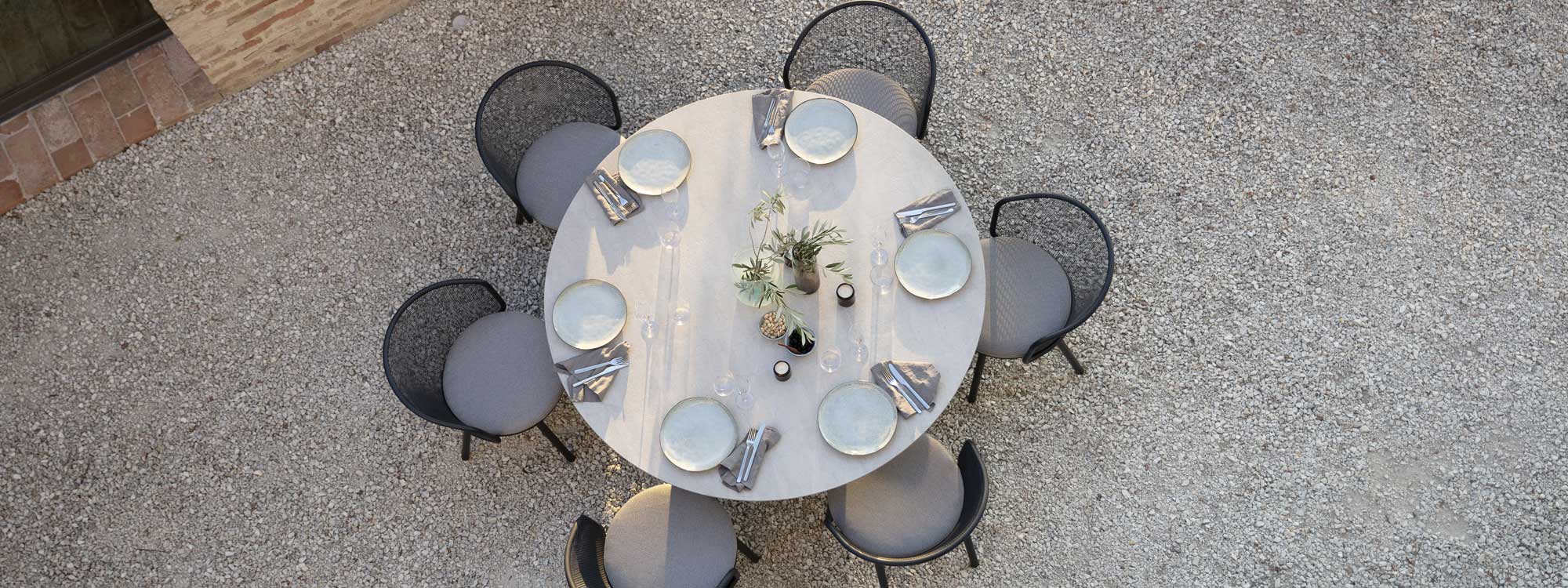 Image of birdseye view of Branta circular outdoor table and Baza garden chairs in gravel courtyard