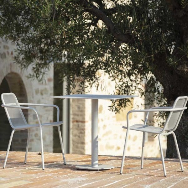 Image of pair of white Starling stacking garden chairs and small Branta pedestal table by Todus on sunny terrace