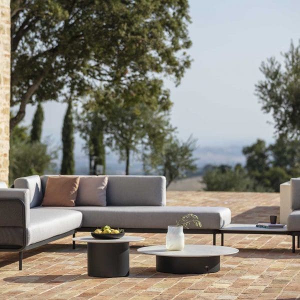 Image of Todus Baza garden corner sofa with different heights and sizes of Branta low tables in the centre