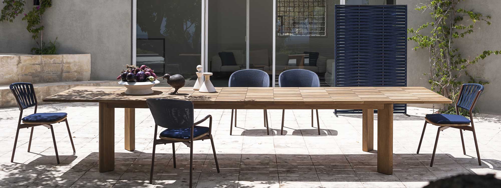 Image of Brick extending teak garden table with Piper chairs and Wing outdoor screen in light and shade of sunny modern terrace