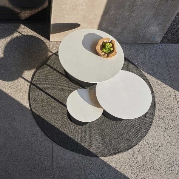 Birdseye view of nest of Royal Botania Butler circular tables on round outdoor rug