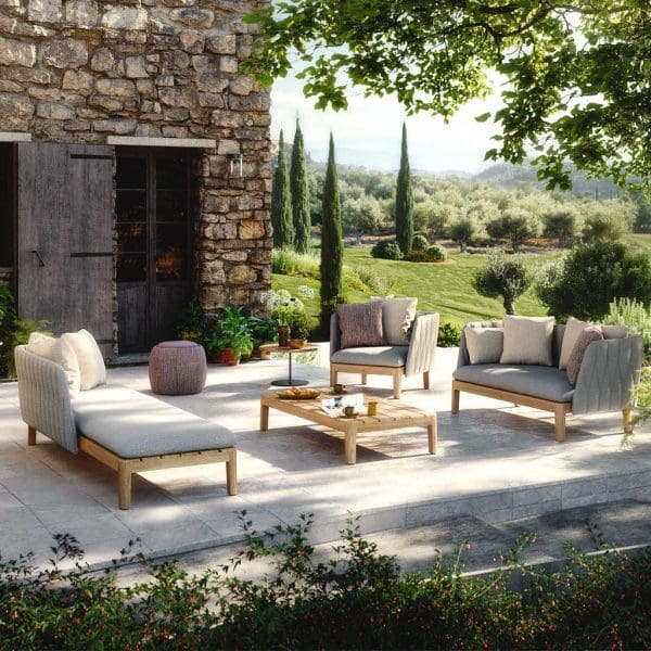 Image of Royal Botania Calypso garden sofa in shaded courtyard with Cypress trees in the background