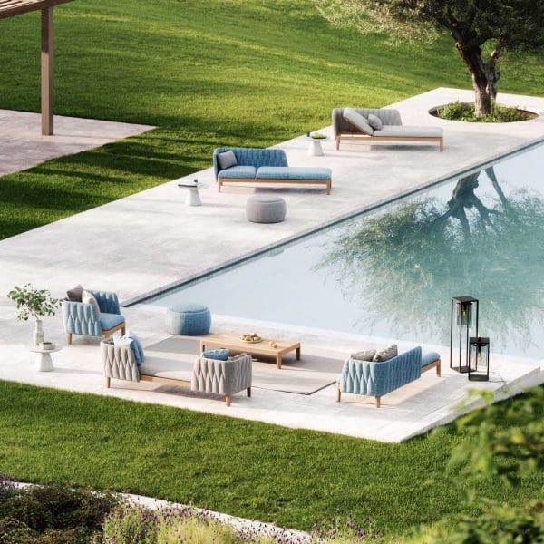 Calypso garden lounge furniture around a poolside with reflection of olive tree in the water.