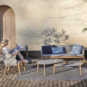 Woman reading magazine, say on Calypso garden sofa from Royal Botania
