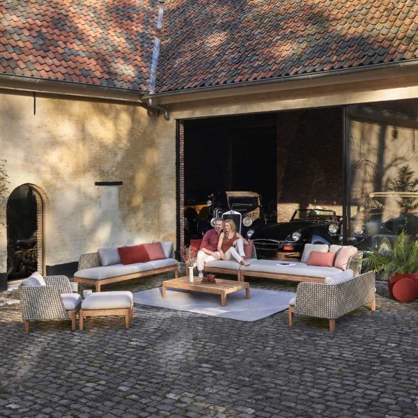Royal Botania Calypso modern garden sofas in cobbled courtyard with classic cars in garage behind.