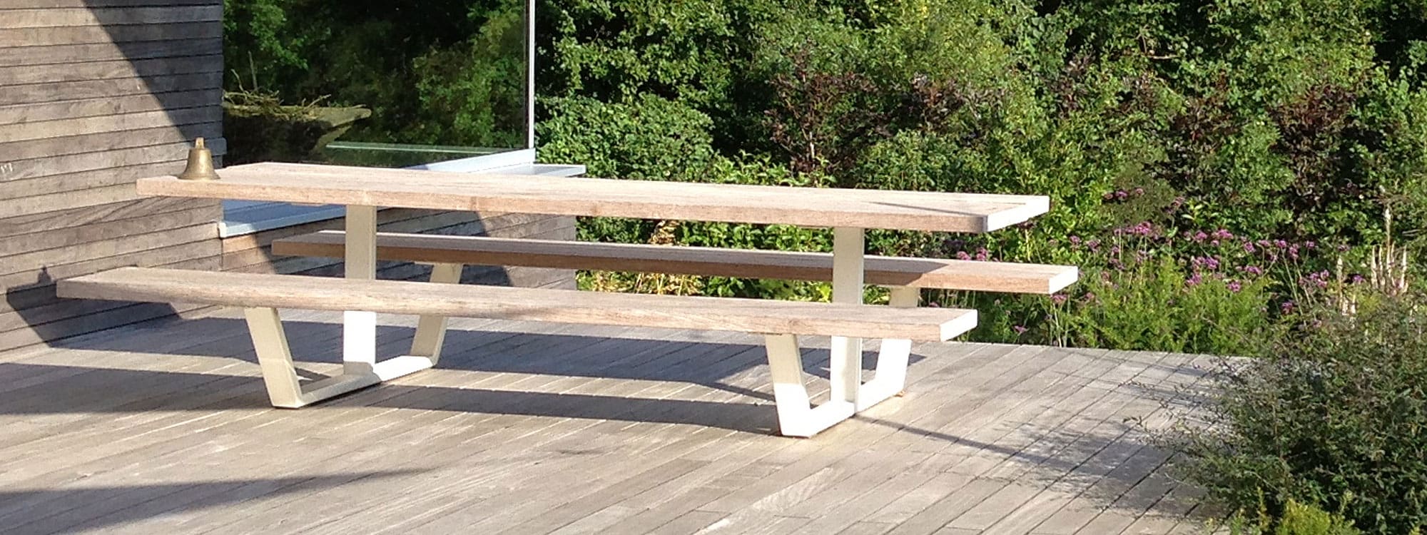 Image of Cassecroute minimalist picnic table with white frame and weathered iroko table and bench surfaces