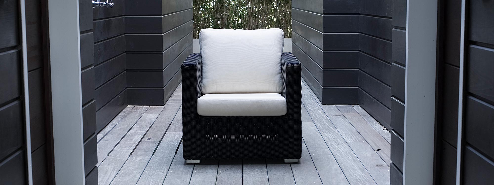 Image of black Chester rattan garden lounge chair with white cushions by Cane-line