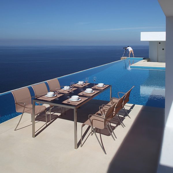 Image of Taupe Taboela table and cappuccino QT55 chairs by Royal Botania on minimalist terrace high above the Mediterranean sea