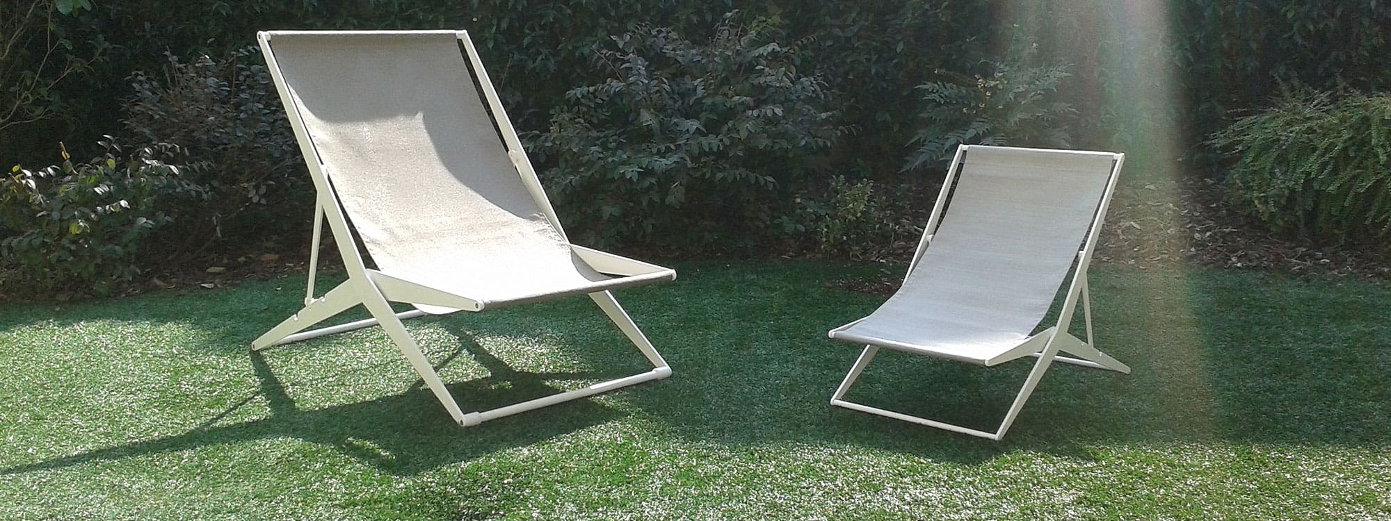 Image of pair of Boomy modern deck chairs with white stainless steel frames and white Batyline mesh slings by Coro, Italy