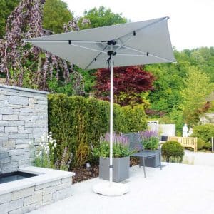 Image of Shademaker Libra square garden parasol with taupe canopy and anodized aluminium mast and ribs, shown on sunny terrace with plants and wall in the background