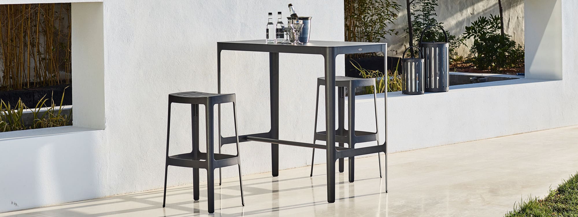 Image of black Cut high bar table and black garden bar stools by Cane-line