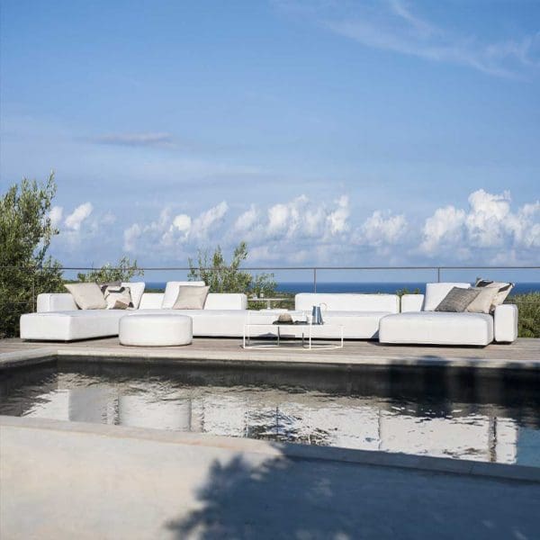 Image of Dandy large white garden sofa on poolside, with fluffy clouds in blue sky and sea in the background