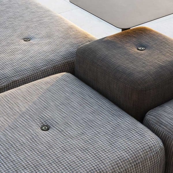 Close-up image of Double upholstered garden poufs next to Bernardo outdoor side table by RODA