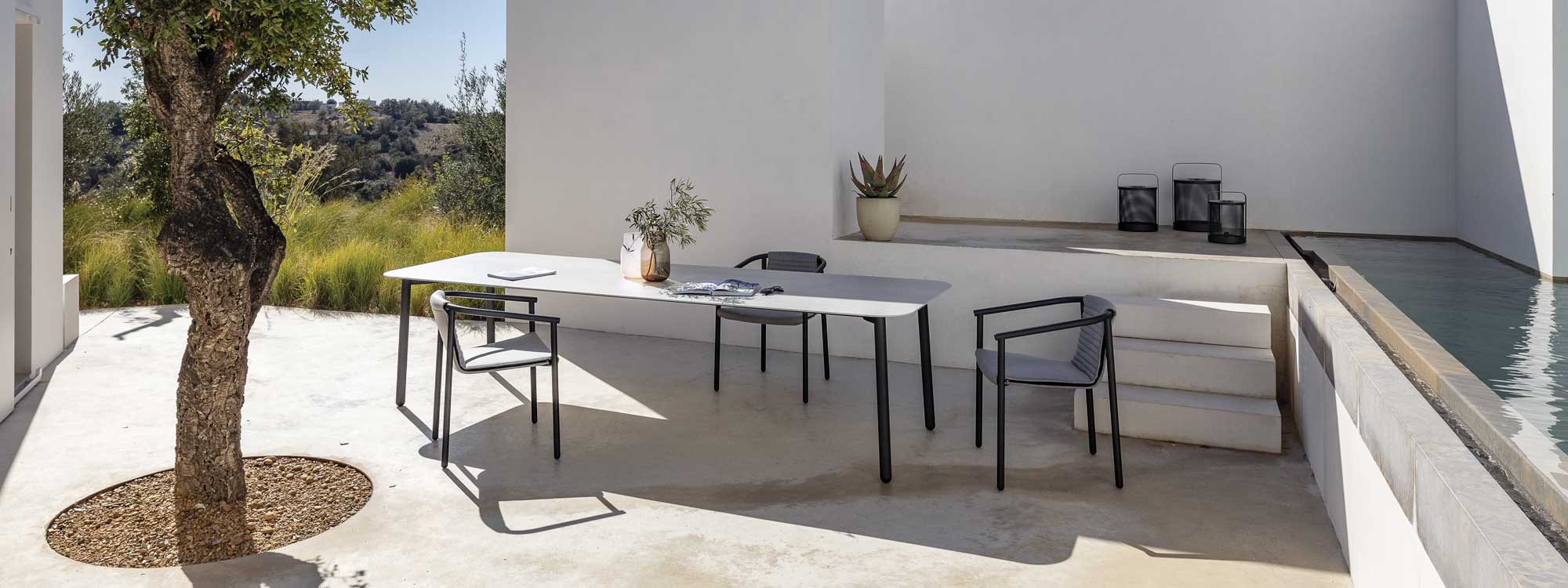 Image of Duct Round garden chair with Starling exterior dining table on minimalist poured concrete terrace