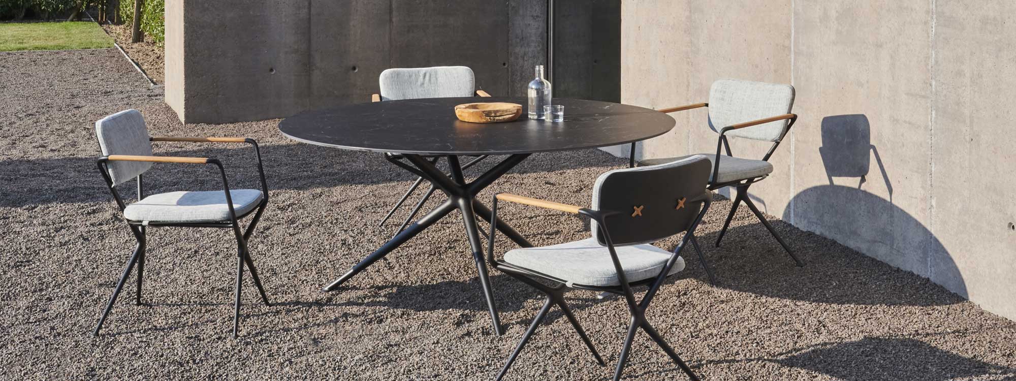 Image of circular Exes table with Nero Marquina ceramic top and anthracite-colored Exes chairs by Royal Botania