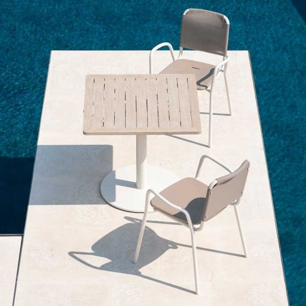 Image of RODA Guest chairs and Stem table in white finish, on small terrace surrounded by swimming pool