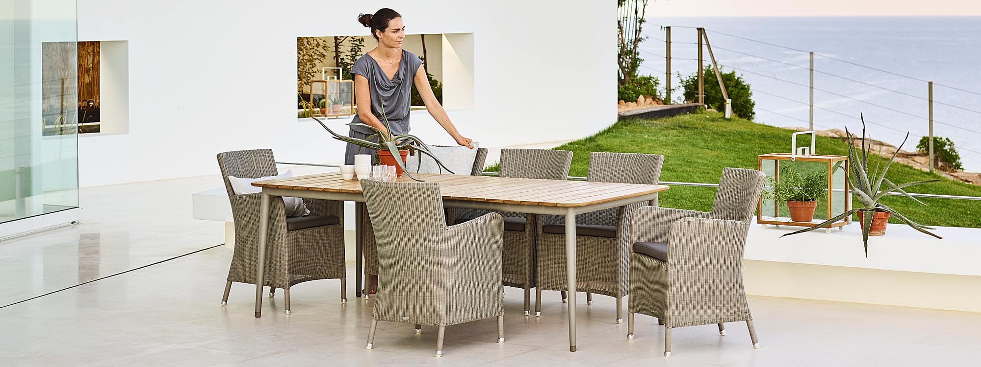 Image of Cane-line Hampsted taupe rattan garden chairs and Core dining table in taupe aluminum & teak on terrace