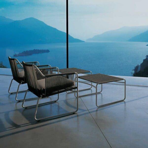 Image of pair of black Harp modern garden lounge chairs on terrace overlooking Italian lake at dusk