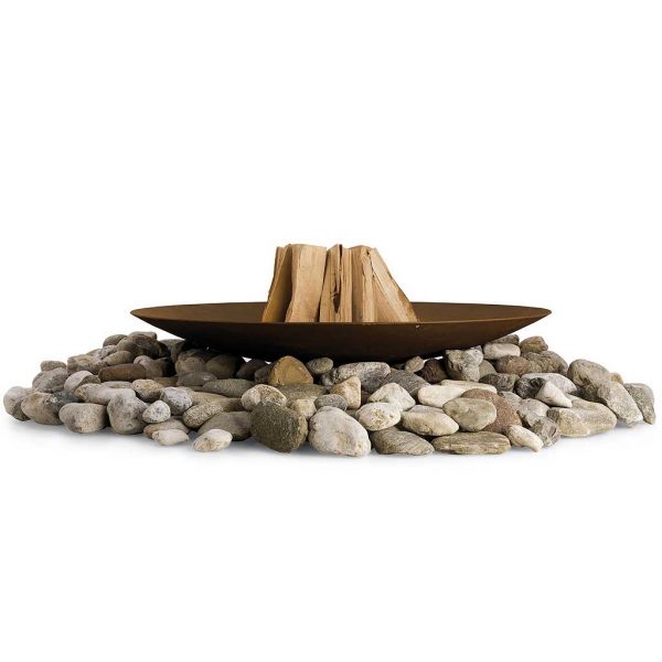 Studio image of Discolo rusted steel fire bowl stacked with logs, sat upon pile of large stones