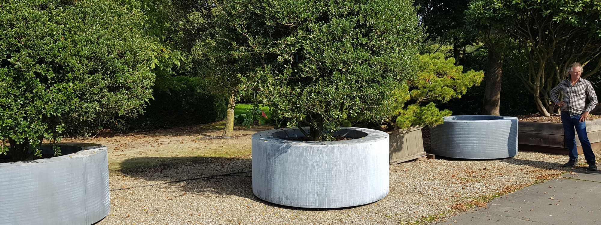 Image of large circular brass planters in weathered finish by Cuprum