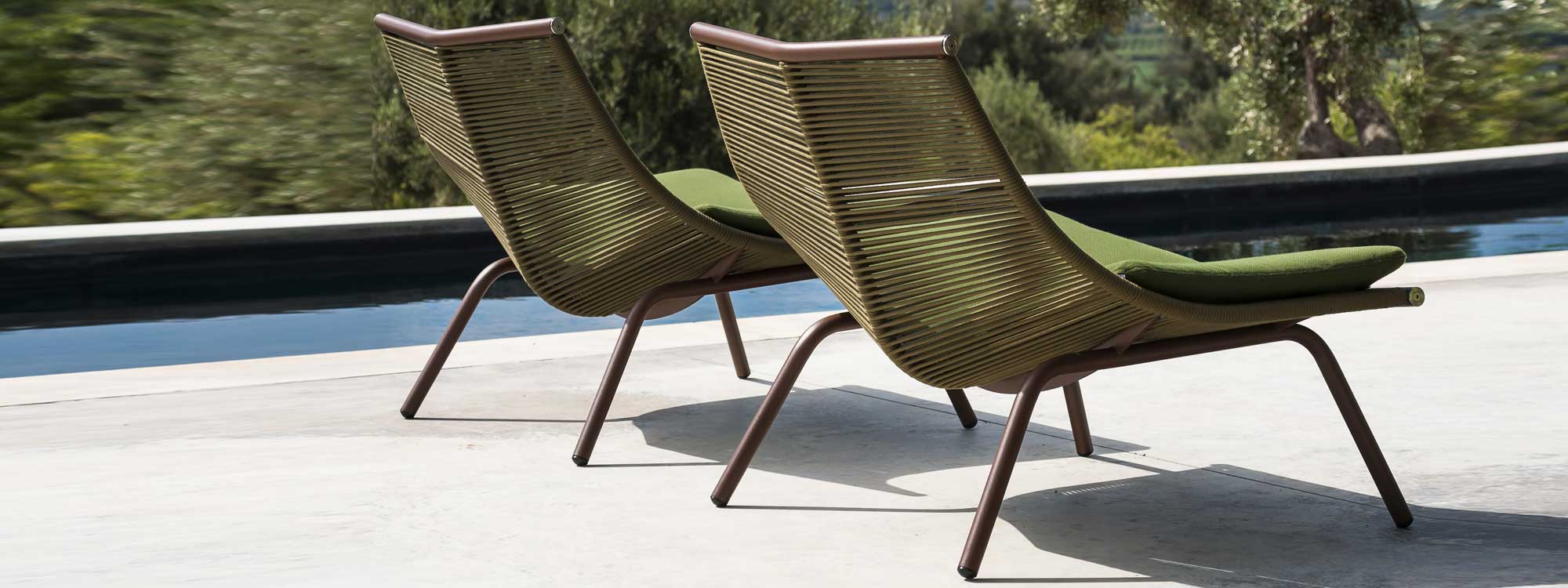 Image of pair of RODA Laze modern garden chairs with rust-colored frame and olive-colored cord seat and back by swimming pool
