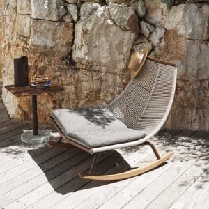 Image of RODA Laze white garden rocking chair with sand cords and teak skids, next to Bernardo pedestal side table
