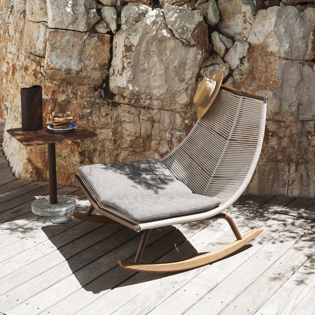 Image of RODA Laze white garden rocking chair with sand cords and teak skids, next to Bernardo pedestal side table