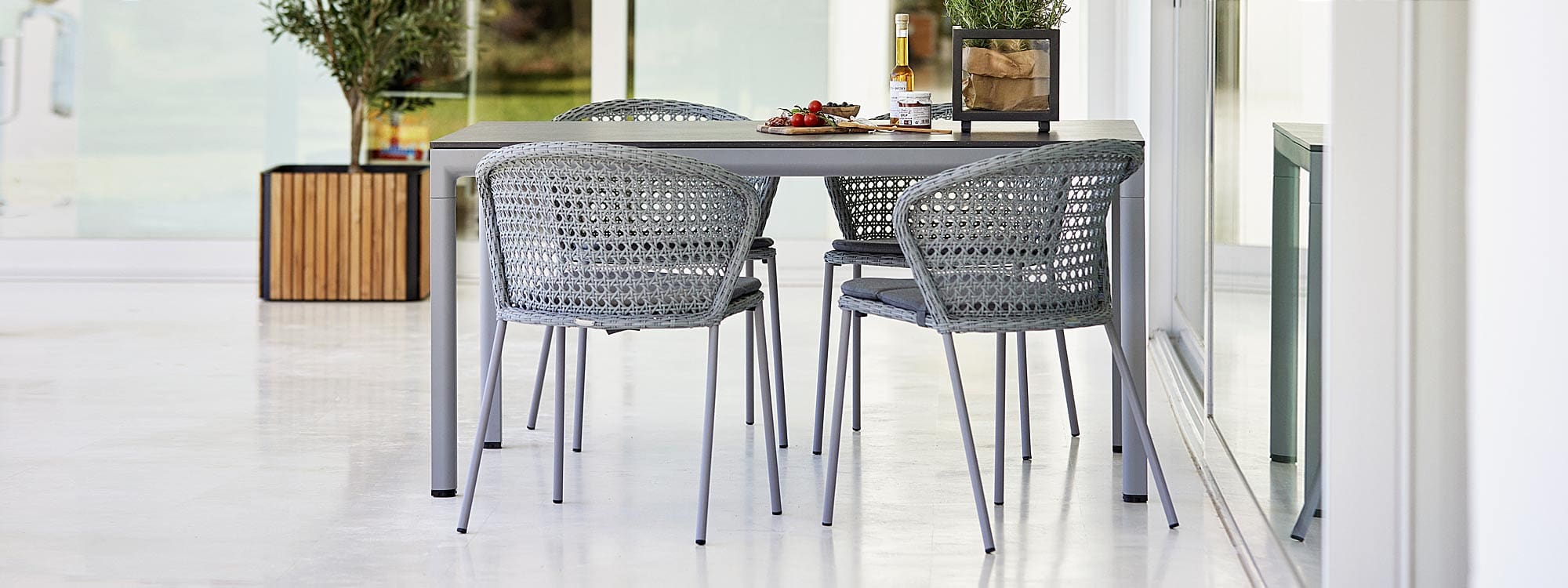 Image of light-grey Cane-line Lean rattan chairs and light-grey Drop garden dining table