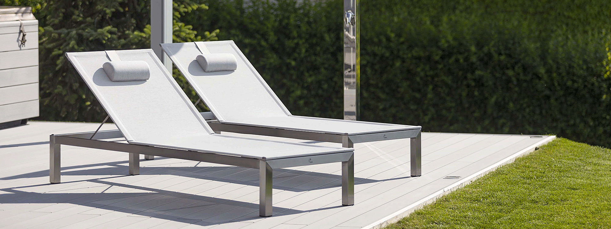 Image of pair of Leuven stainless steel sun loungers with white Batyline seat and backrest on sunny terrace