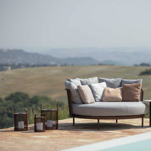 Image of Baza daybed on poolside with Todus Luci lanterns to the side, with arid summer hills in background