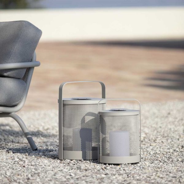 Image of Grey-Silk coloured Luci LED outdoor lanterns on gravel next to Starling modern garden lounge chair by Todus