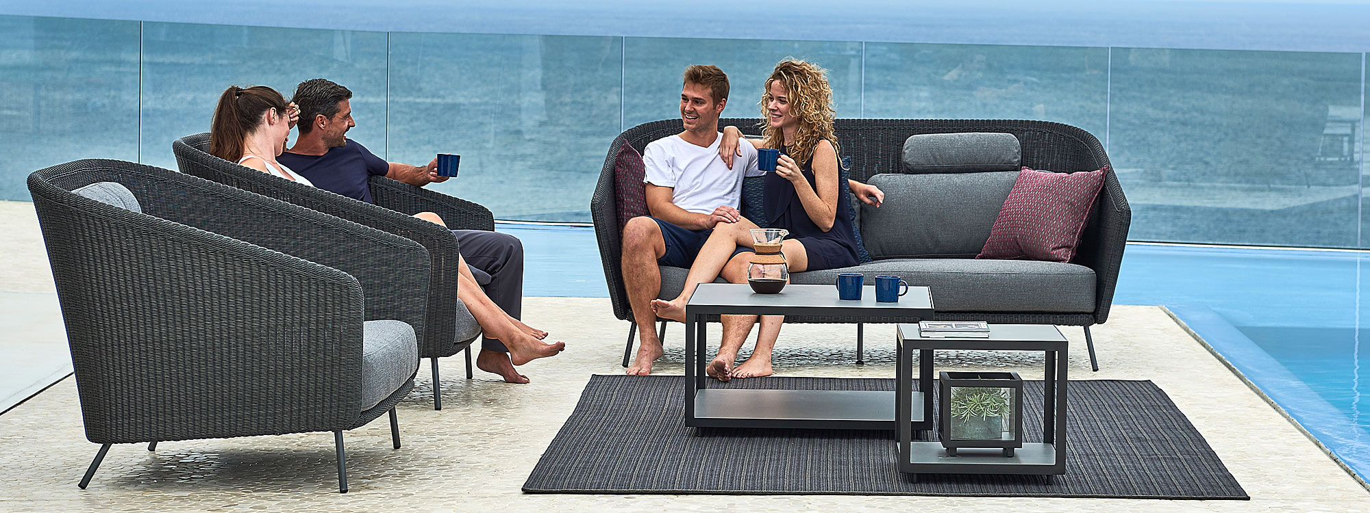 Image of 2 couples sat drinking coffee on terrace on Cane-line Mega modern rattan sofa set