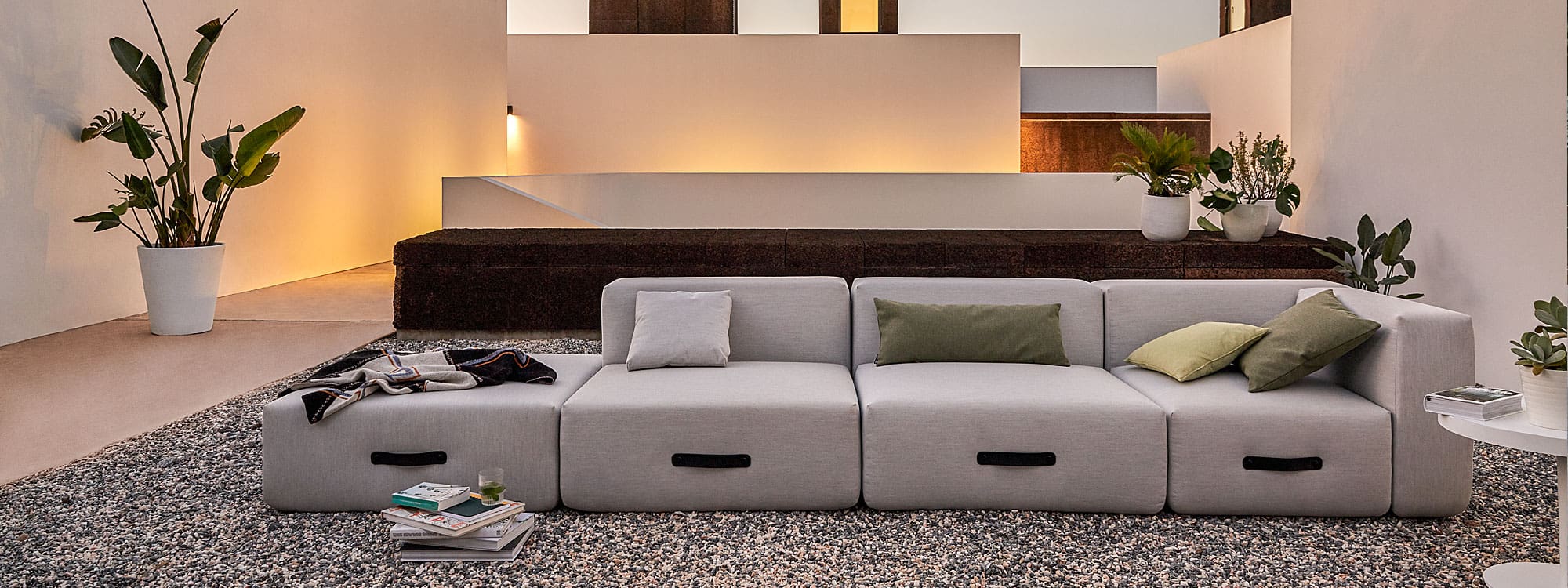 Image at dusk of Miami garden sofa in minimalist Mediterranean courtyard