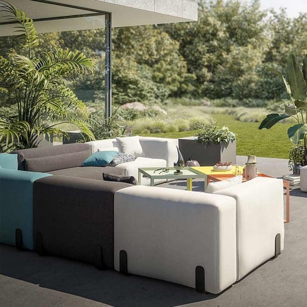 Image of Miami modern outdoor corner sofa in grey, blue and light-grey, with garden and woodland in the baclground