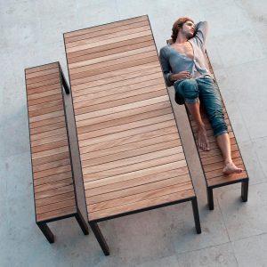 Image of dude in cardigan lying on Roshults modern garden bench in teak & anthracite stainless steel