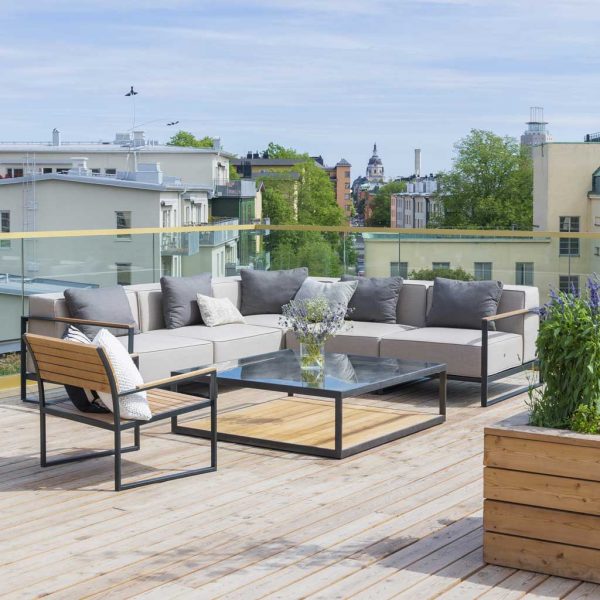Image of rooftop terrace and Moore outdoor corner sofa, with rooftops, trees and church spire in the background