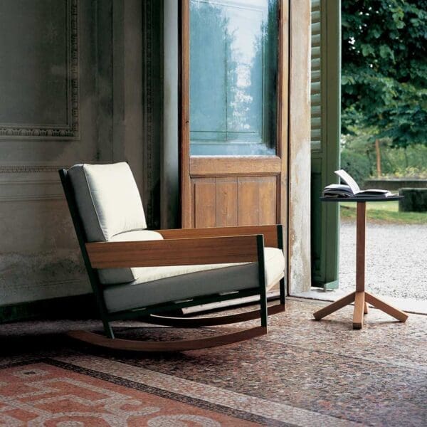 Interior shot of Nap garden rocking chair and Root teak side table by RODA, next to open door looking out onto garden