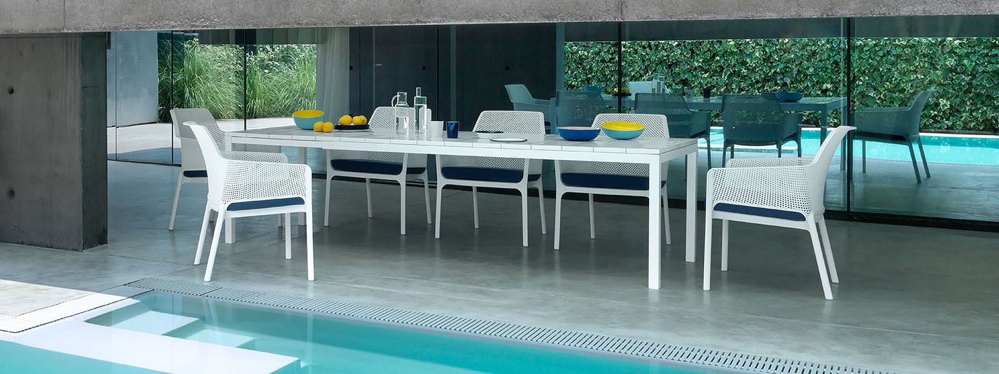 Image of Nardi Net white garden armchairs and Rio extending dining table on poolside