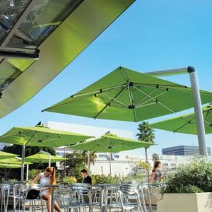 Image of Shademaker Orion cantilever parasols with lime green canopies shown above bistro furniture