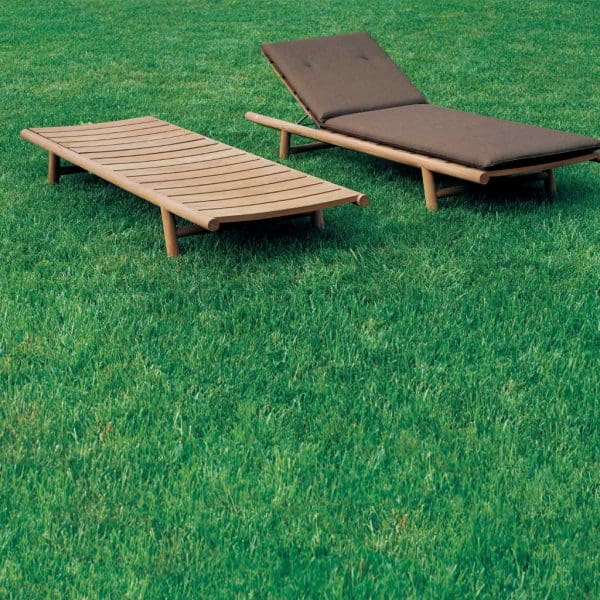 Image of pair of RODA Orson teak adjustable sun beds on green lawn, one with a brown cushion