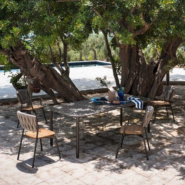 Image of closed RODA Piper extendable garden dining table and Piper chairs beneath shade of tree on terrace