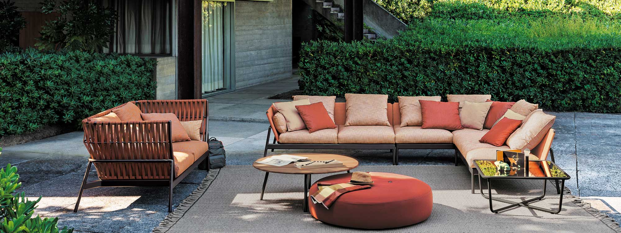 Image showing Piper high back garden sofa and regular back outdoor sofa with orange backs and orange cushions, with Double round garden pouf by RODA in the center