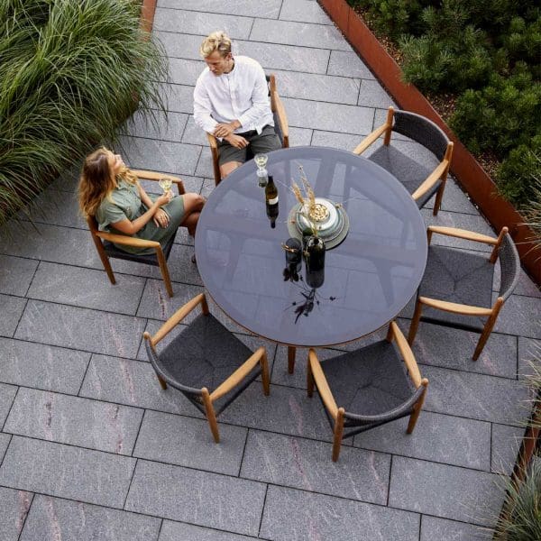 Image of birds eye view of 6 Royal Teak armchairs around Aspect round garden table by Caneline