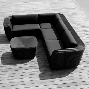 Image of aerial view of black Savannah woven corner sofa with black cushions by Cane-line, shown on wooden decking