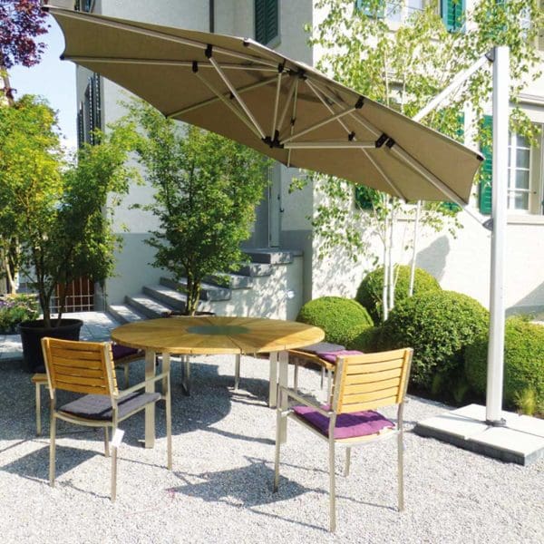 Image of tilted Shademaker Sirius octagonal cantilever parasol above garden table and chairs