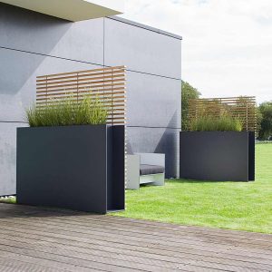 Image of pair of Sotomon raise planters against concrete wall, with white Riva garden lounge chair in between
